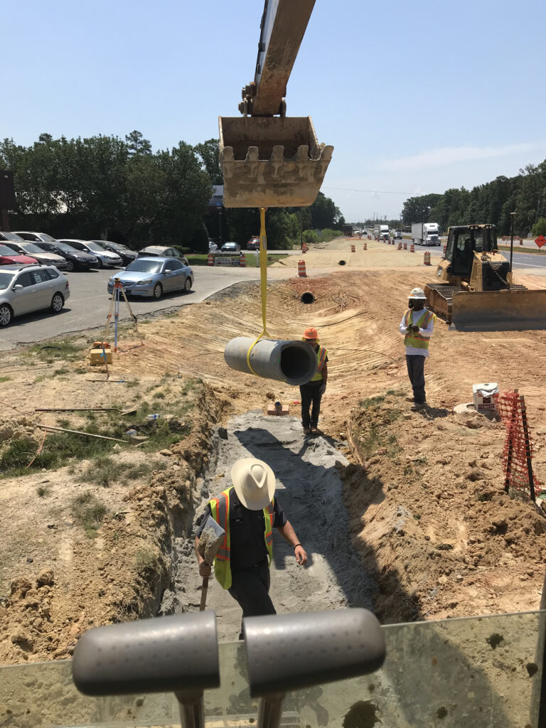 Workers installing drainage pipe.